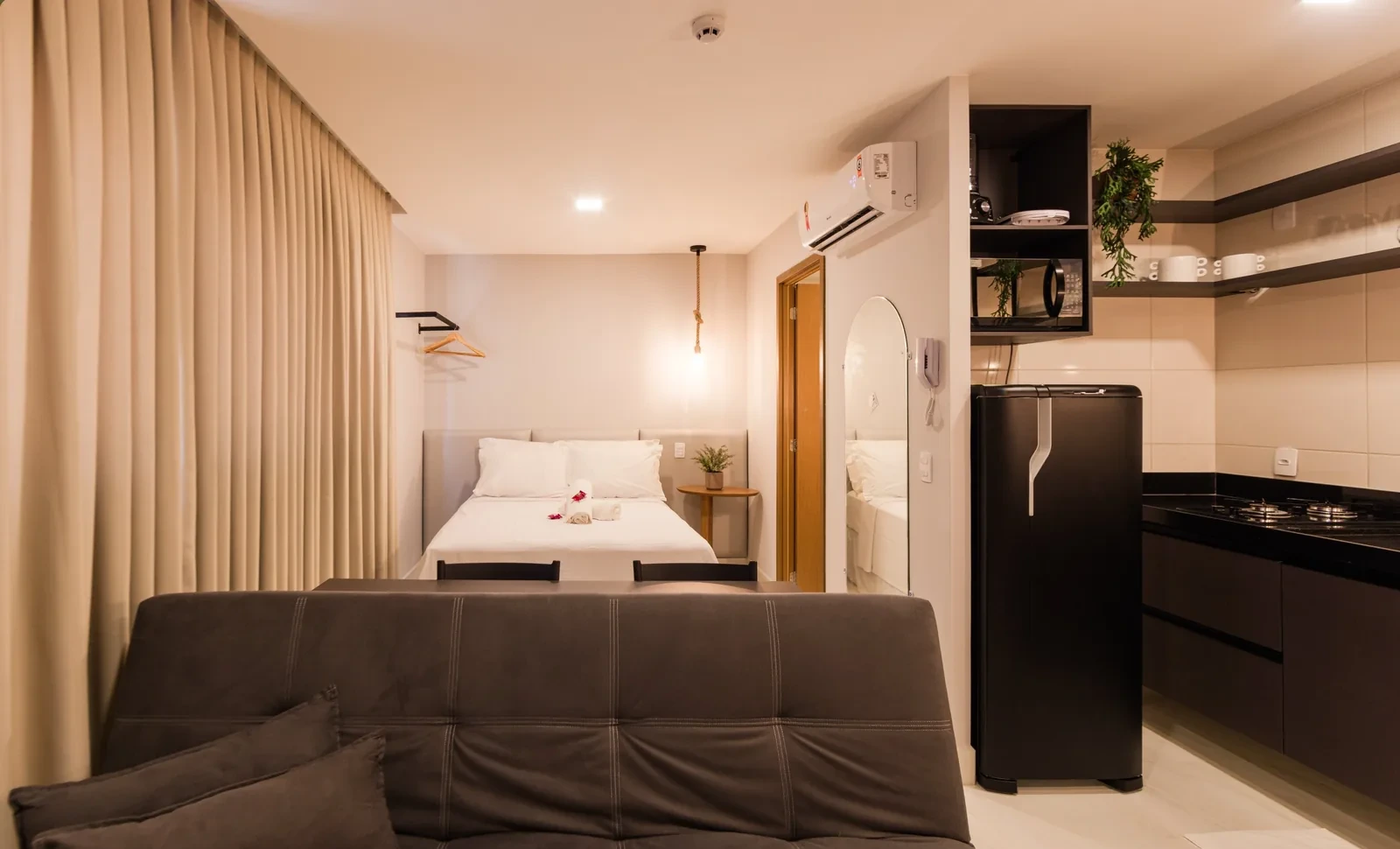 Quarto Duplo Gaudium Flats — vista da cama e área de estar